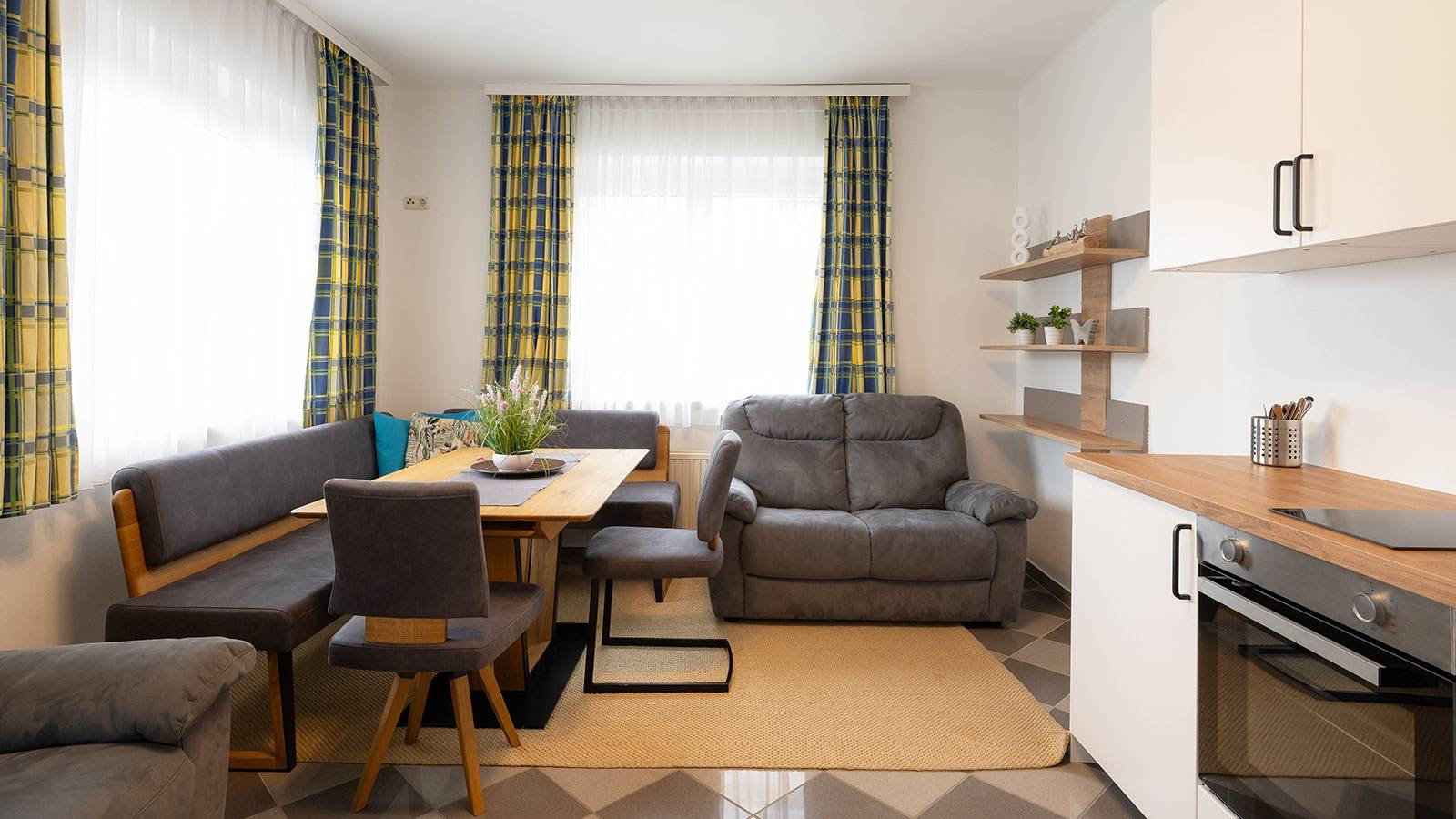 Wohnküche mit Esstich, Sofa und Küchenzeile