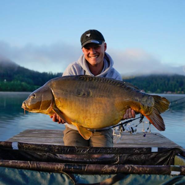 Fischer am Klopeiner See hält den geangelten Fisch in den Händen.