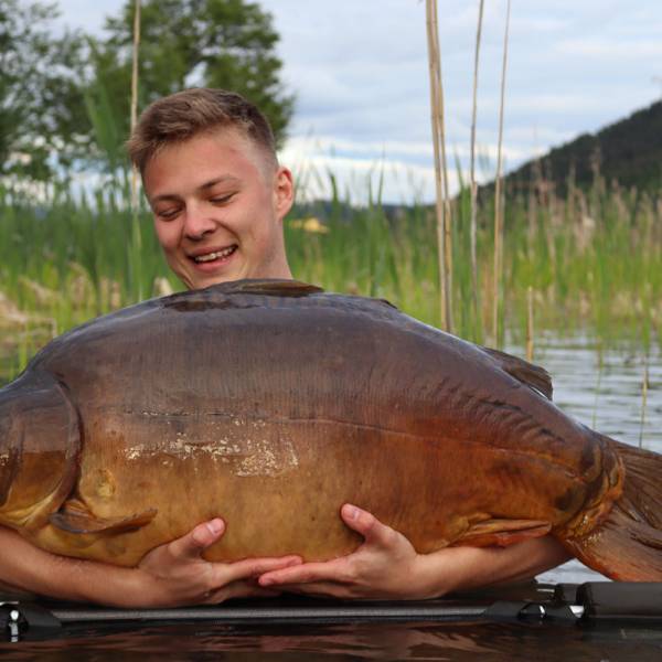 Fischer am Klopeiner See hält den geangelten Fisch in den Händen.